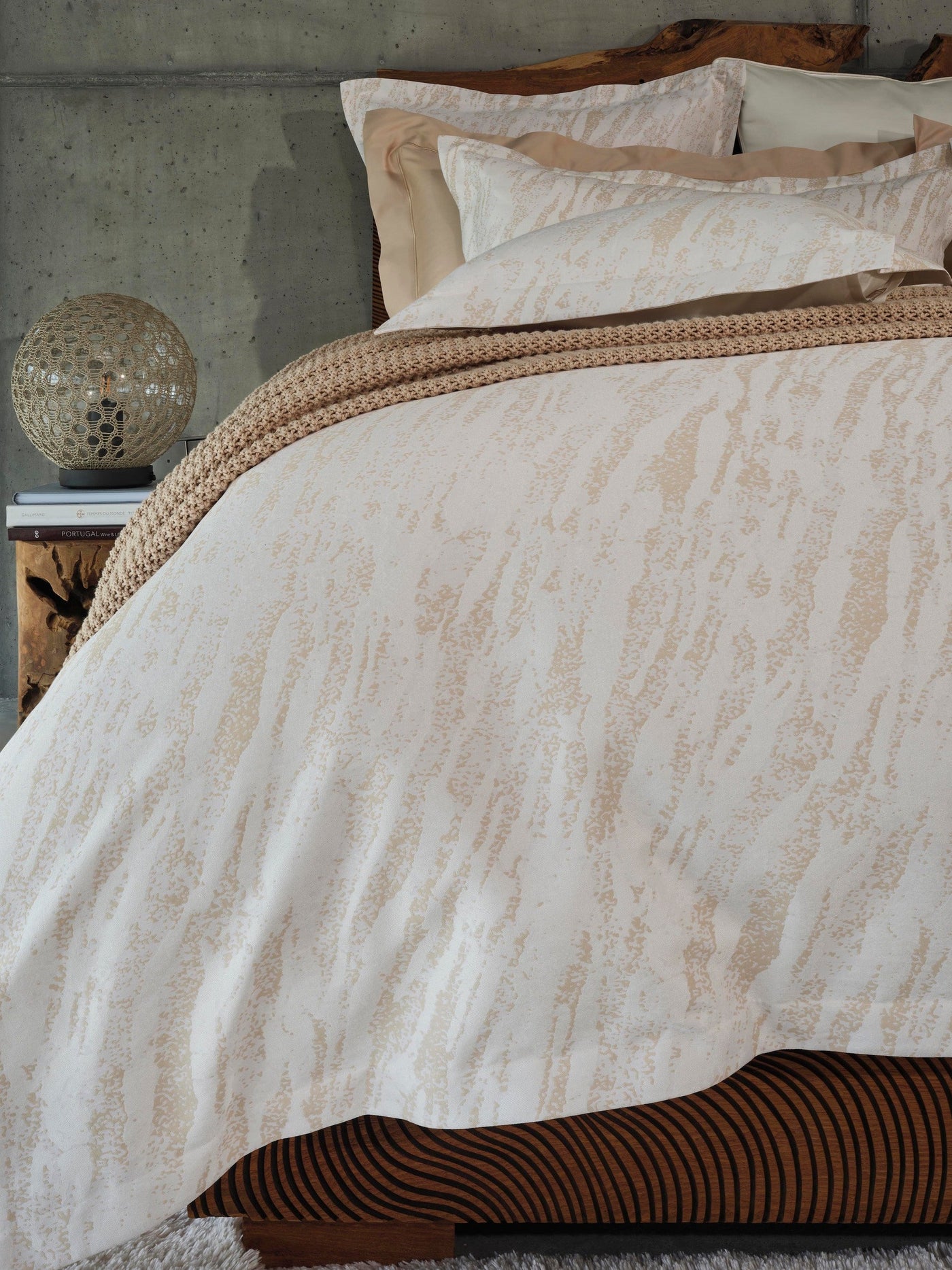 Close-up of Neve pillowcases in ivory with champagne abstract brushstroke pattern.