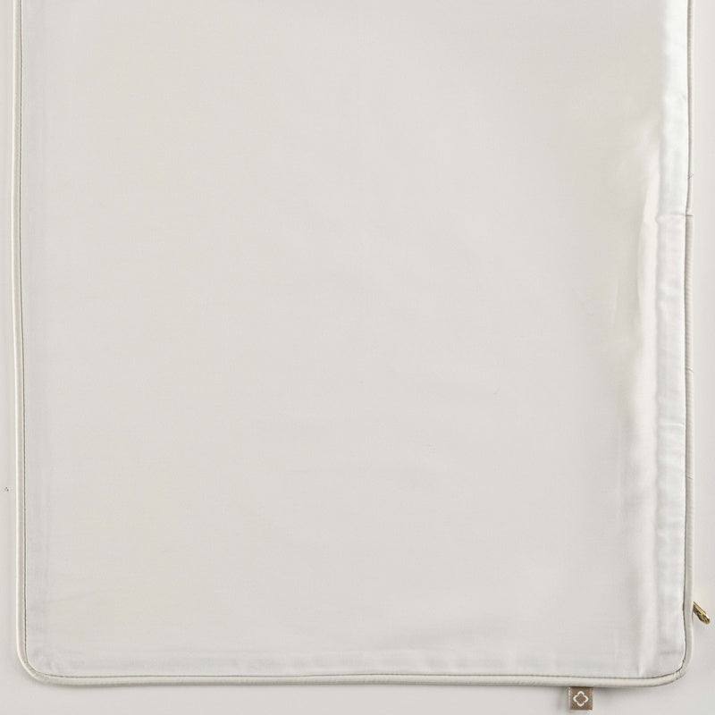 Close-up of a white pillow cover with a piped edge and subtle texture, featuring Noa Pillow Cover by Celso de Lemos available at Linen Society.