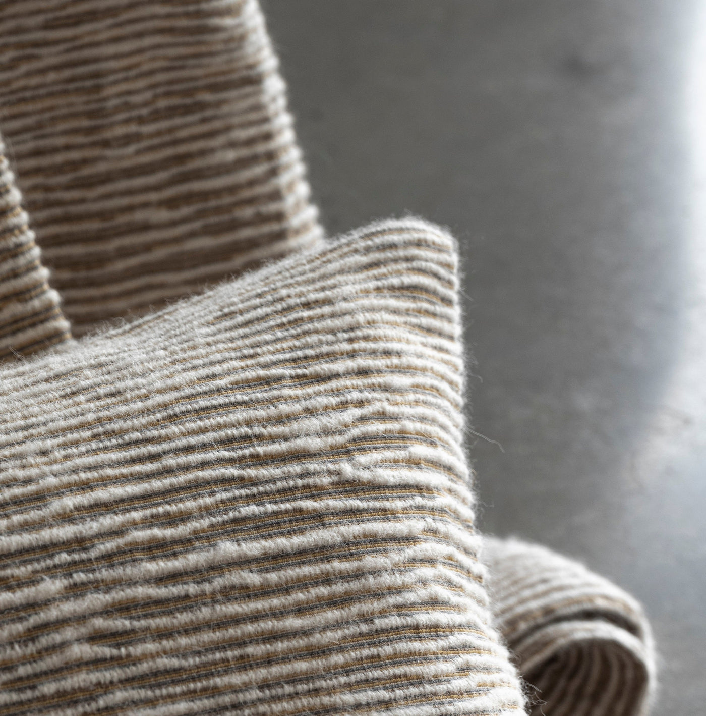 A striped pillow cover with a textured weave in neutral tones, featuring Panama Pillow Cover by Celso de Lemos available at Linen Society.