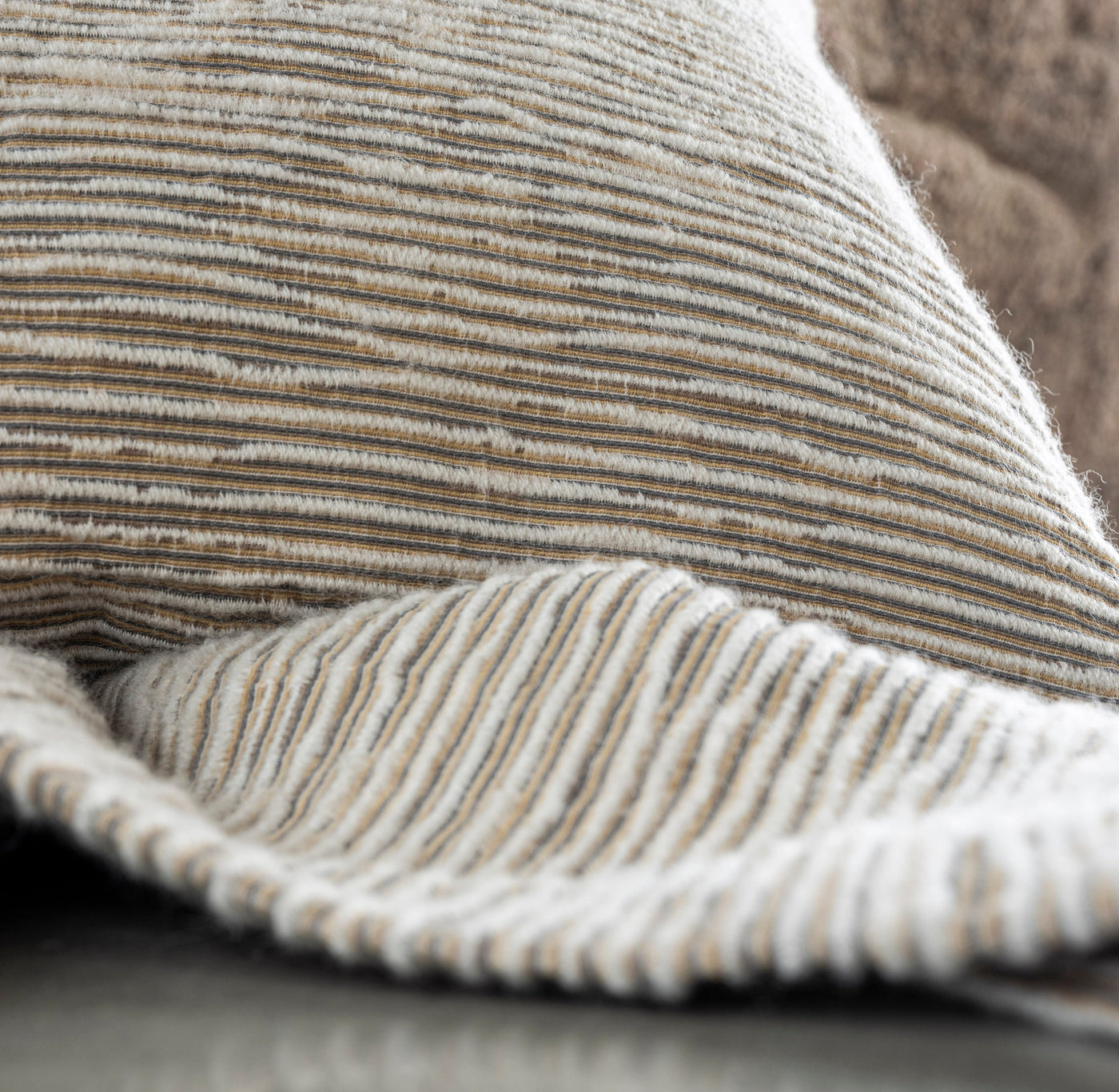 A close-up shows textured, striped fabric in cream, tan, and grey. featuring Panama Pillow Cover by Celso de Lemos available at Linen Society.