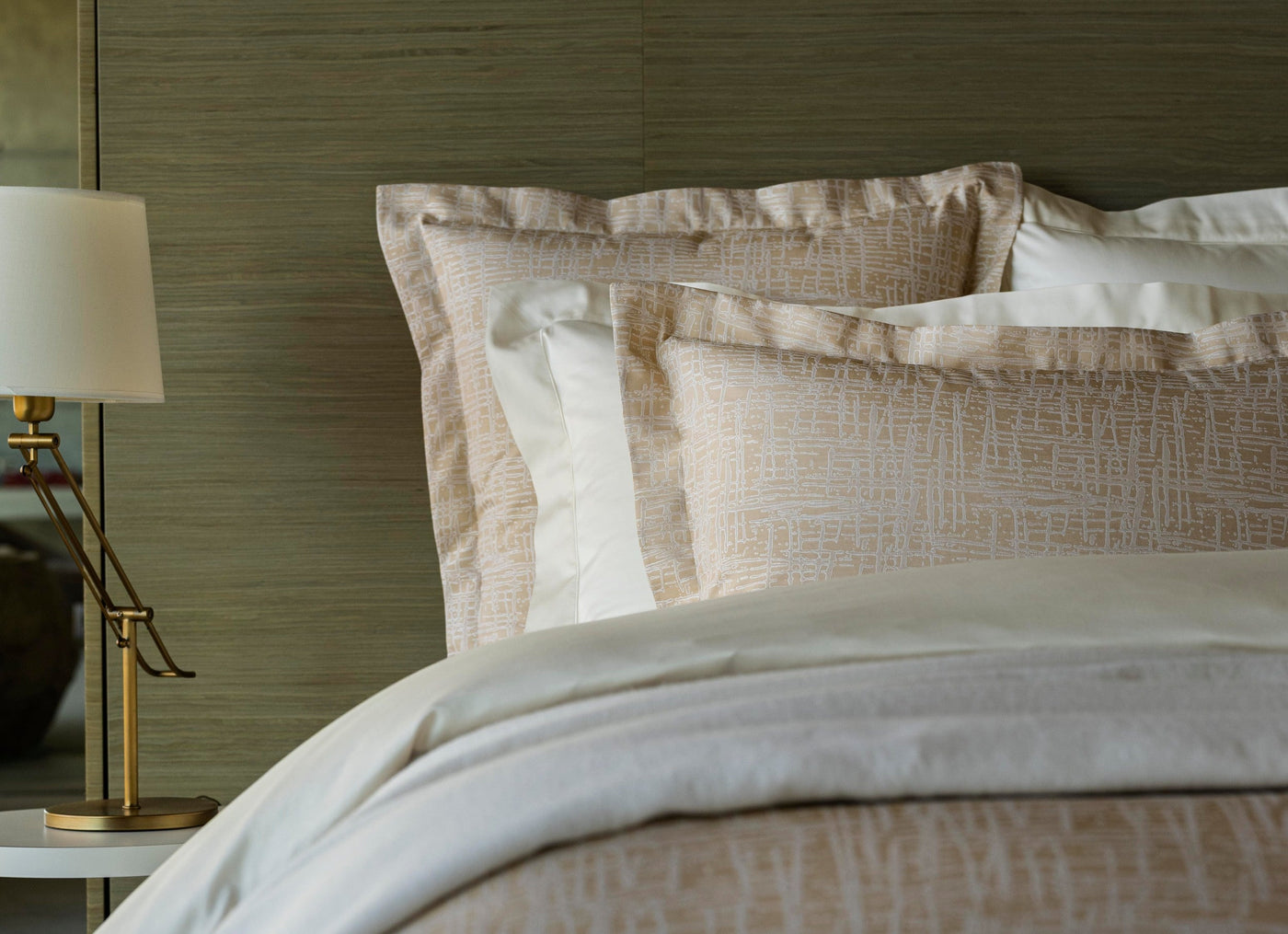 Champagne textured euro shams layered over ivory pillows on a styled bed.