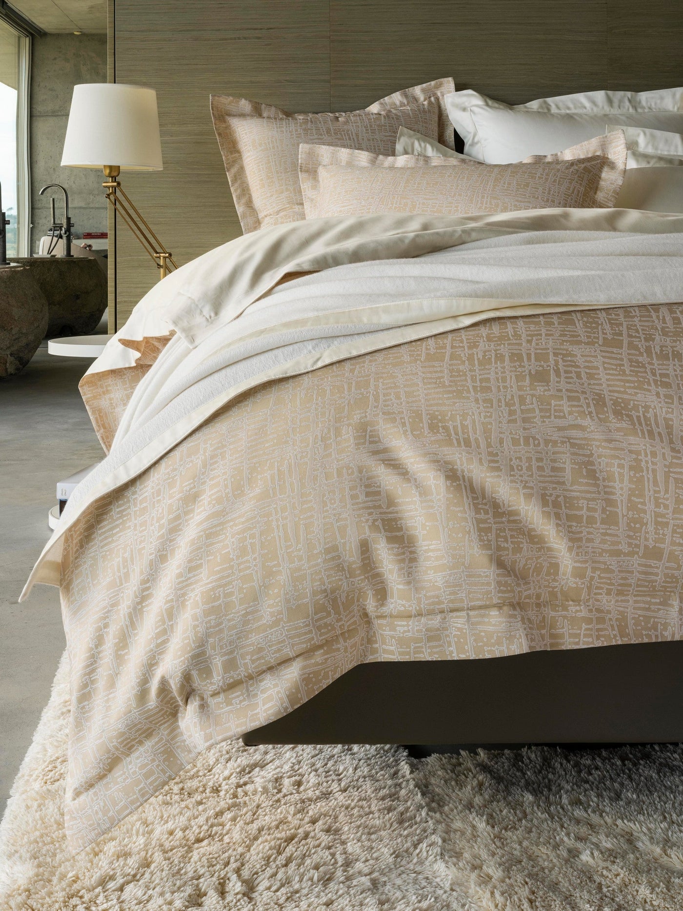 Champagne textured duvet and pillowcases styled on a bed, seen from a low angle.