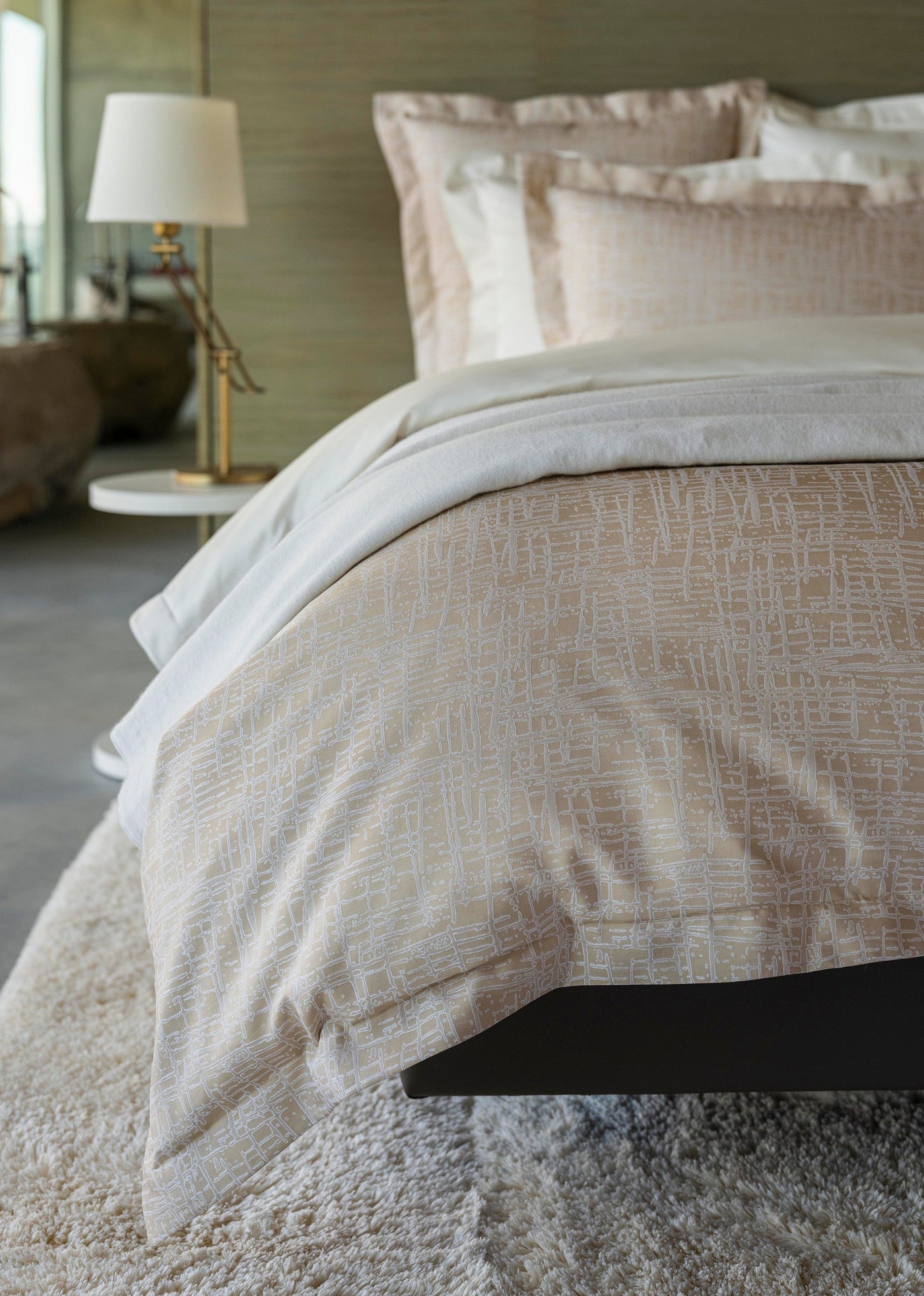Close-up of champagne Celso de Lemos Partition bedding with textured woven pattern on styled bed.