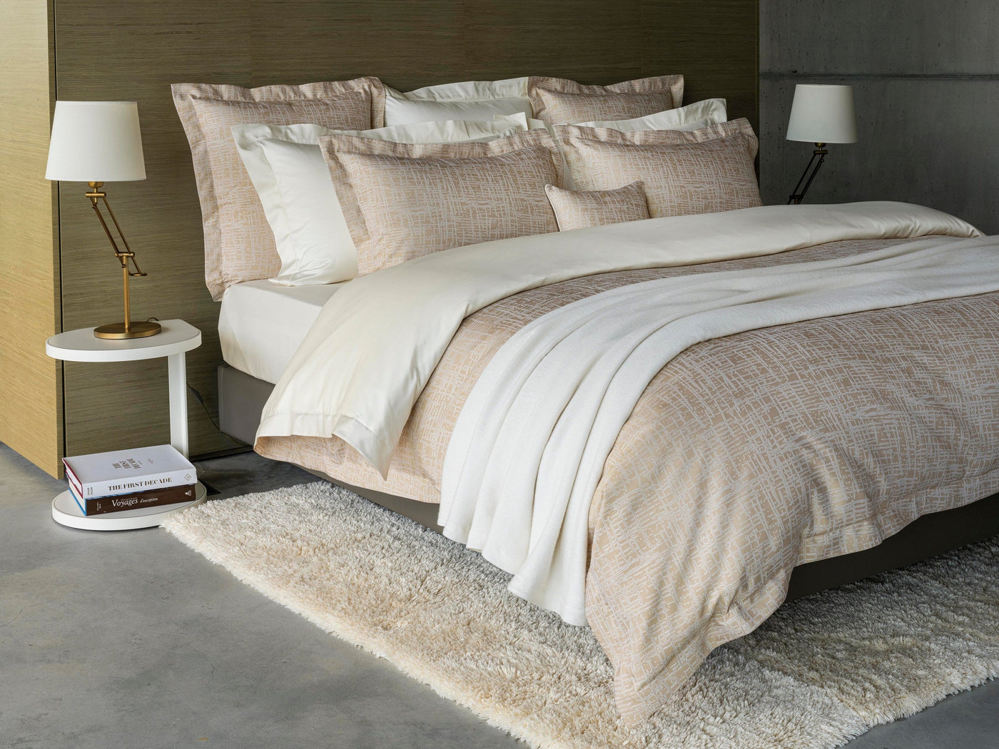 Ivory and blush linen pillowcases styled on a made bed with layered neutral bedding.