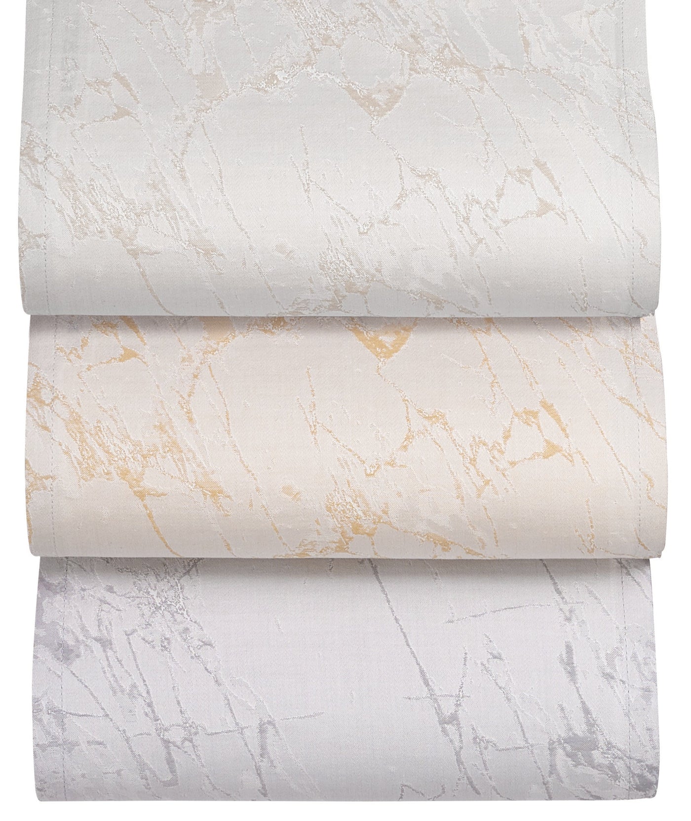 Three Celso de Lemos Parus duvet covers stacked, showing silver, gold, and grey marble patterns.