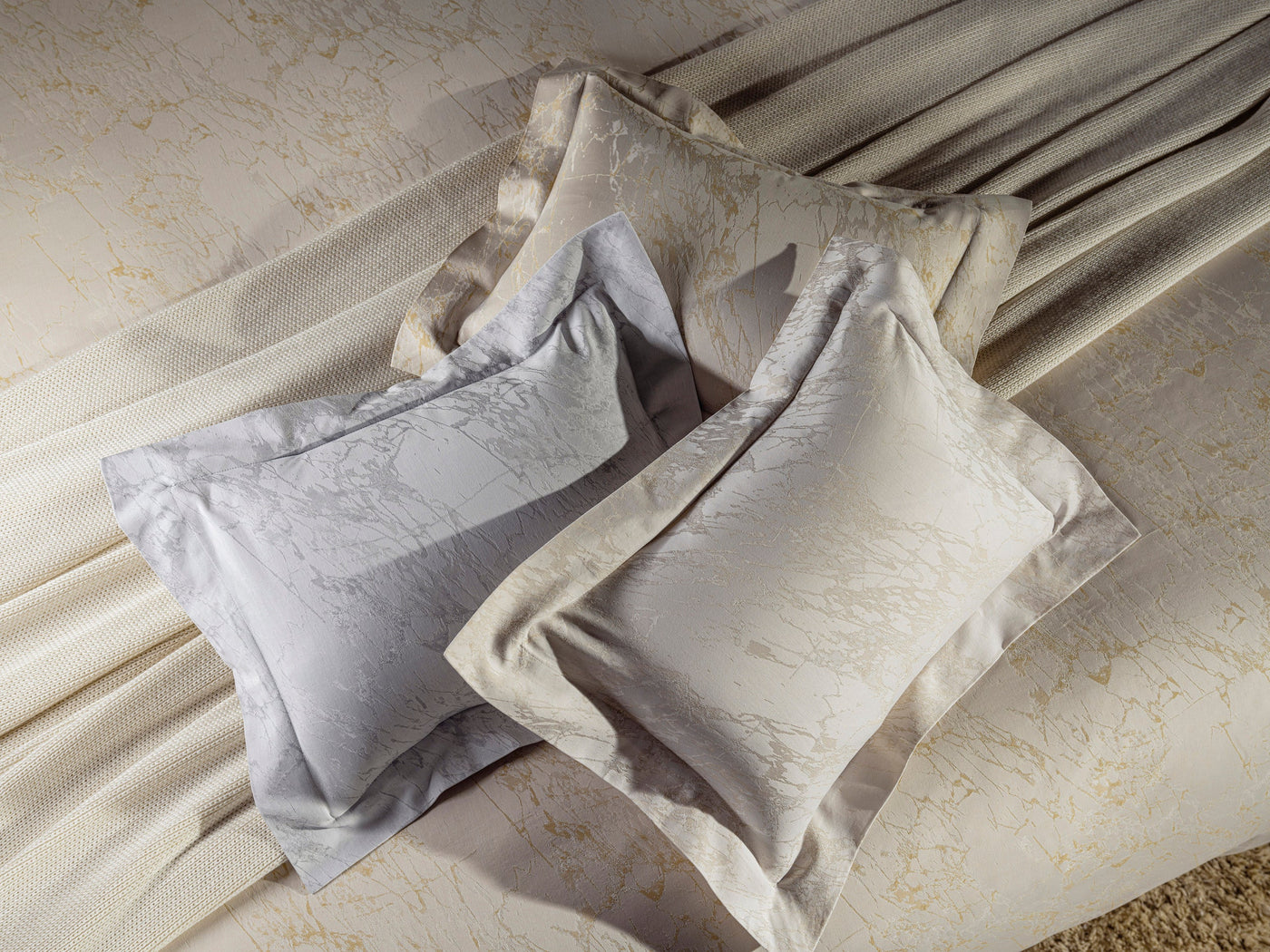 Celso de Lemos Parus pillowcases in silver and ivory, jacquard pattern, styled with draped fabric.