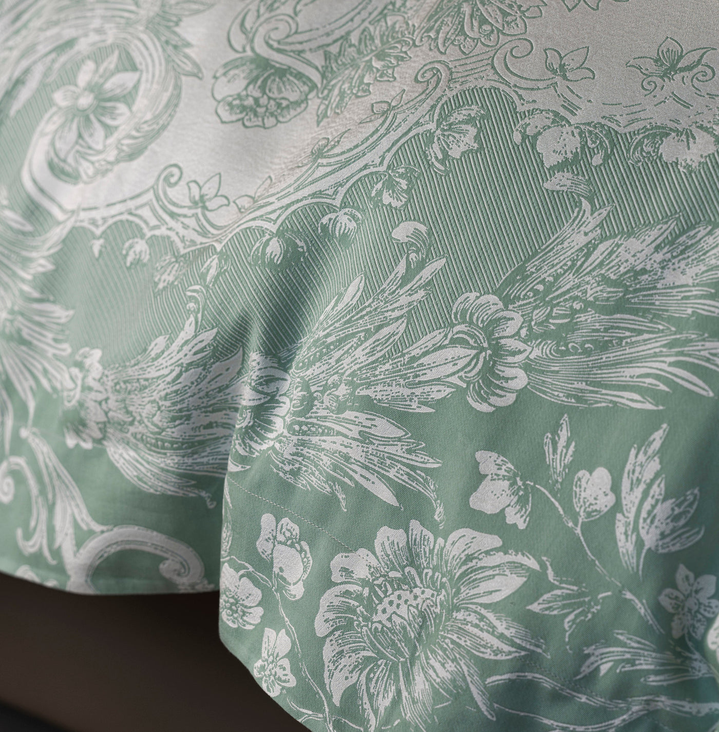 Close-up of Celso de Lemos Pompadour duvet cover in sage, showing jacquard floral damask weave.