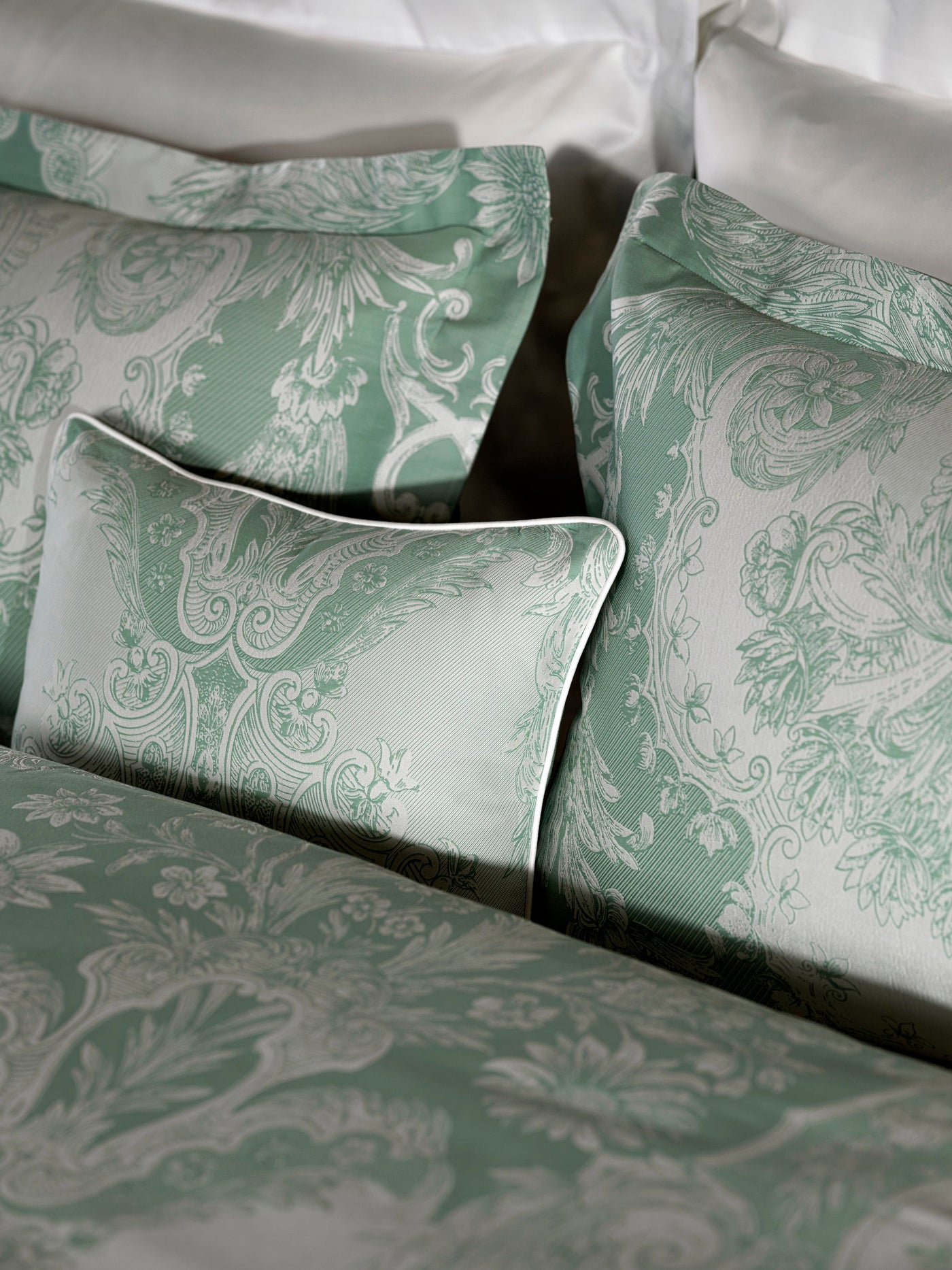 Close-up of Celso de Lemos Pompadour pillowcases in sage, baroque damask jacquard.