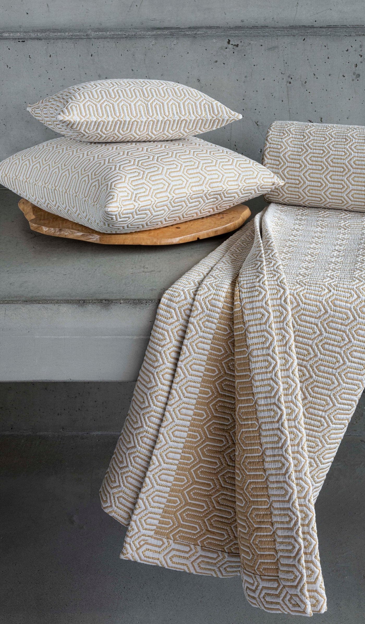 Close-up of geometric woven Vendome pillow covers and throw in champagne and ivory.