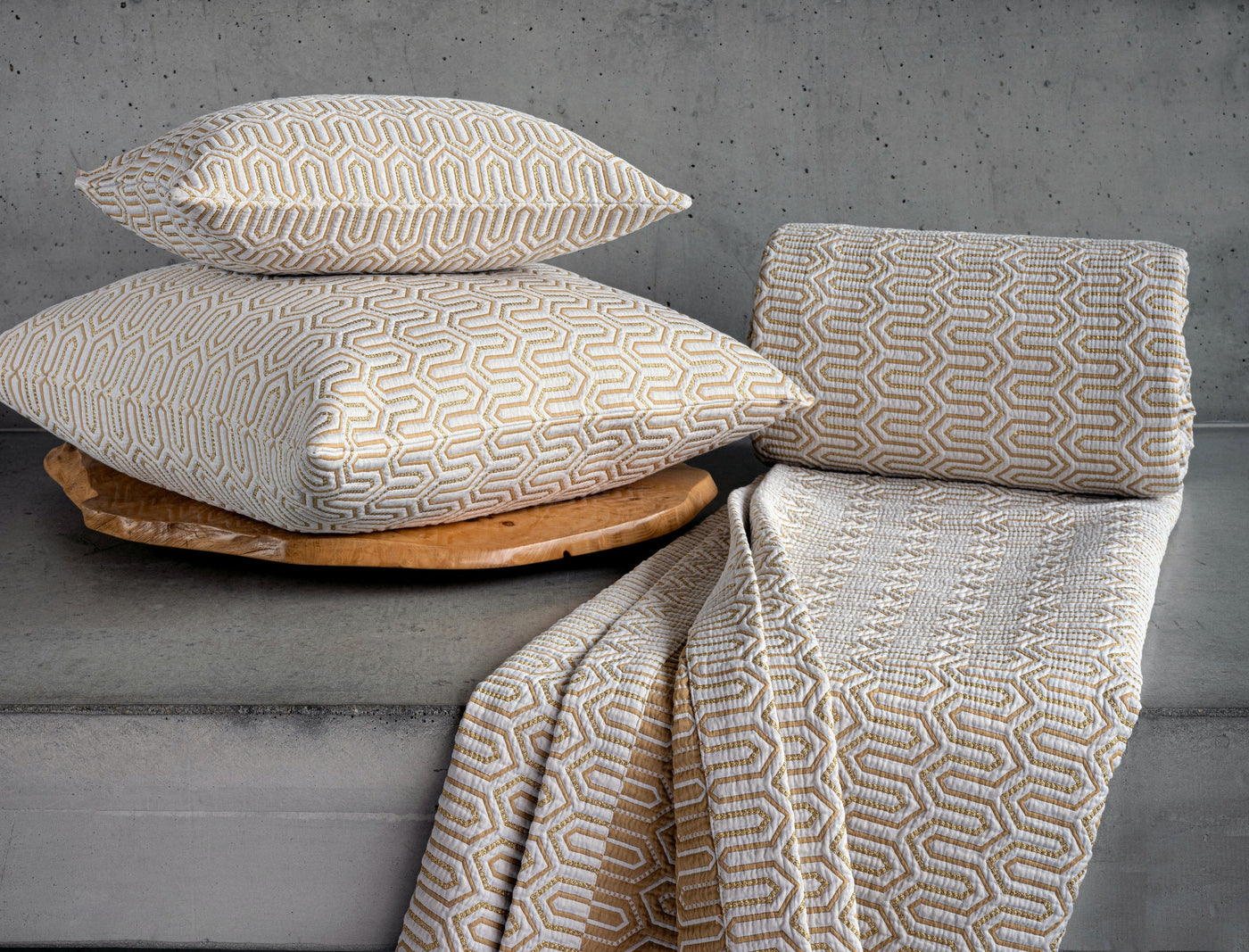 Celso de Lemos Vendome pillow covers in gold geometric jacquard, styled with matching throw.