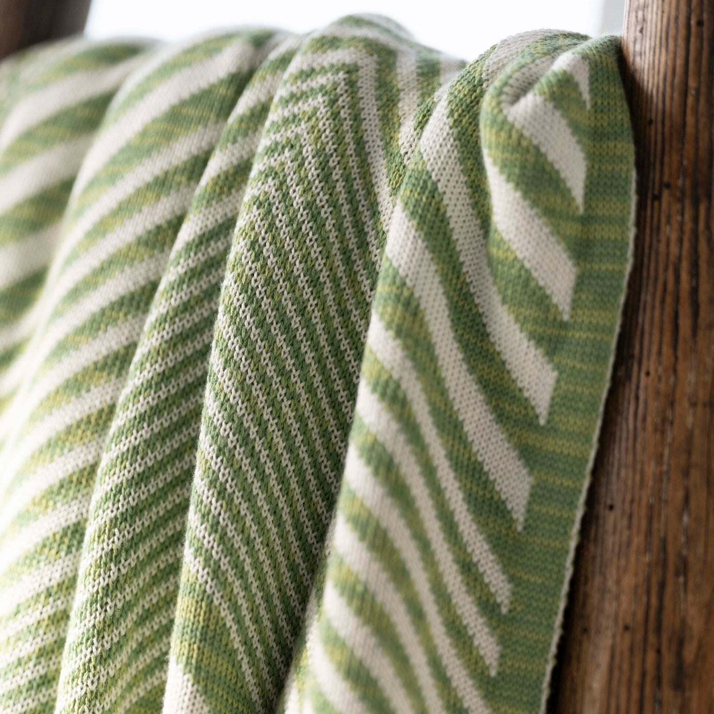 Green and white striped fabric draped over a wooden surface
