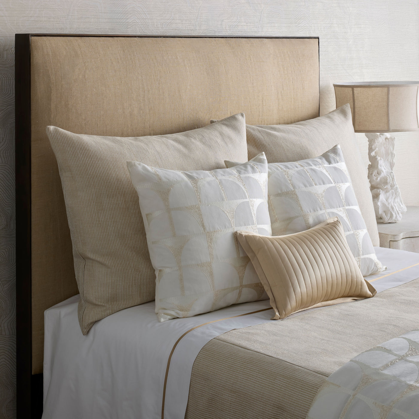 Champagne velvet Channel Quilt pillow styled on a neutral-toned bed with layered ivory pillows.