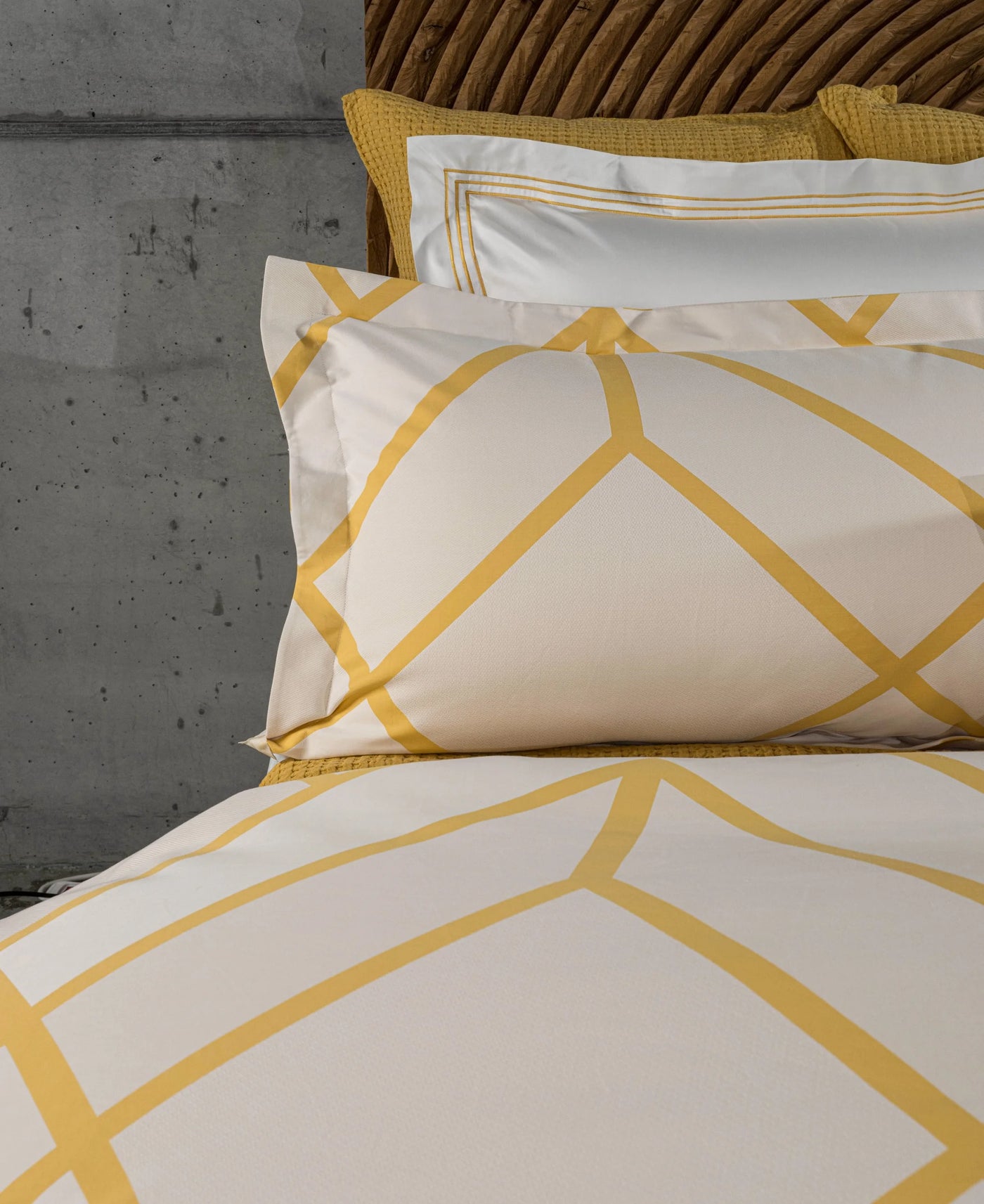 Close-up of saffron geometric lattice pattern on ivory cotton pillowcase.