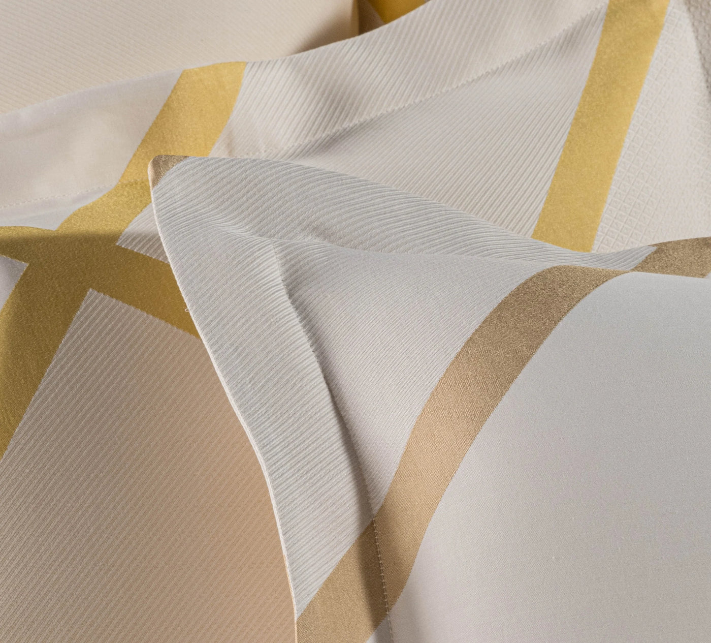 Close-up of Charleston pillowcase showing gold geometric border on white cotton fabric.