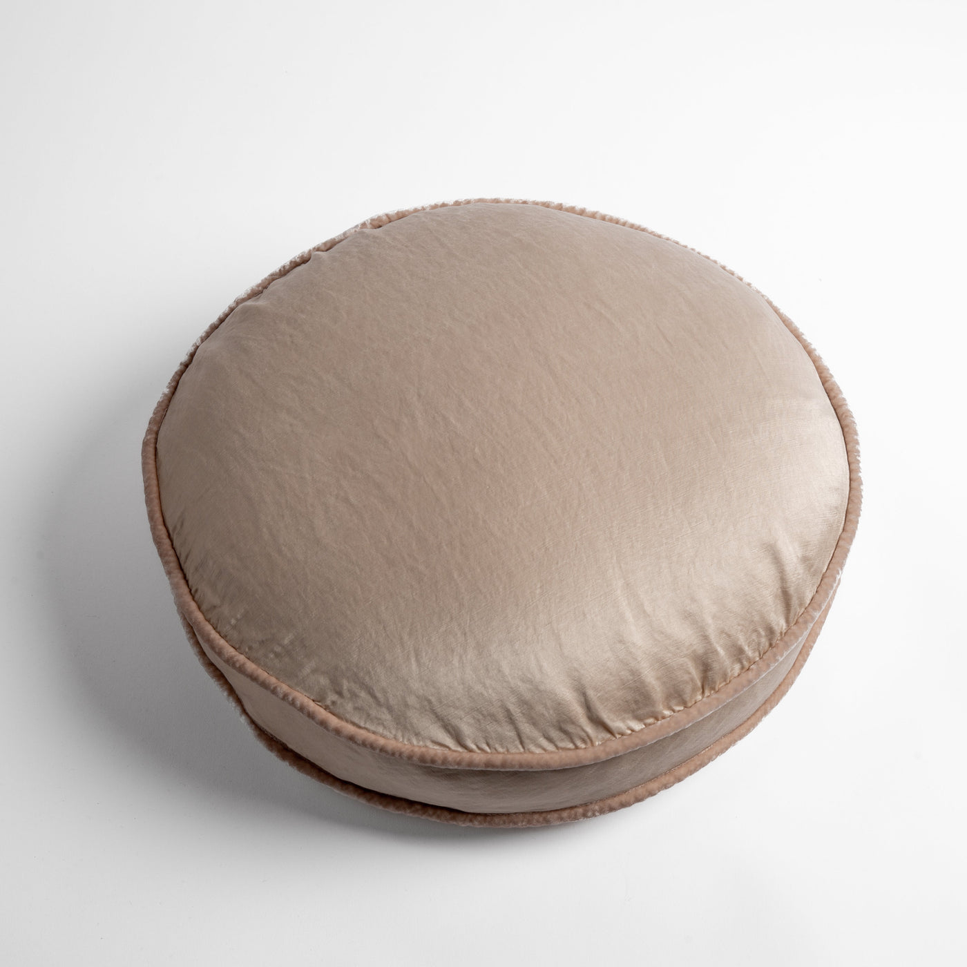 Round Bella Notte Paloma throw pillow in Pearl, shown from above with visible corded edge trim.