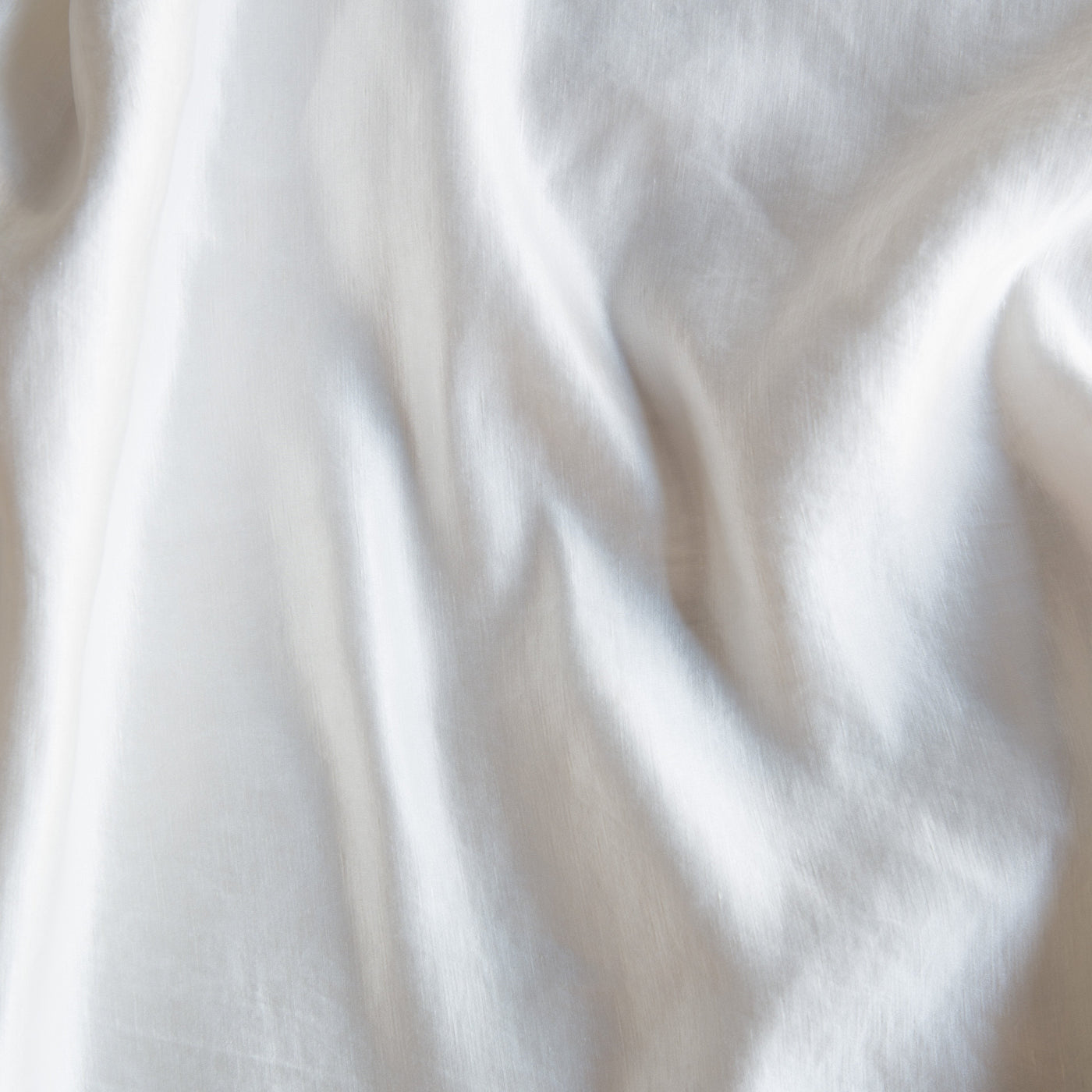 Close-up of draped White Bella Notte Paloma fabric showing soft linen texture and natural folds.