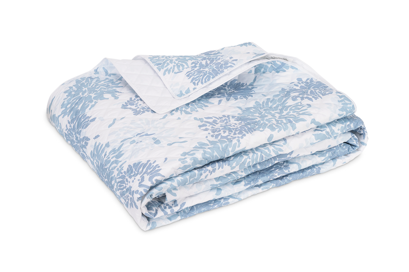 Matouk Chrysanthemum quilt in sky blue floral print, neatly folded on white background.