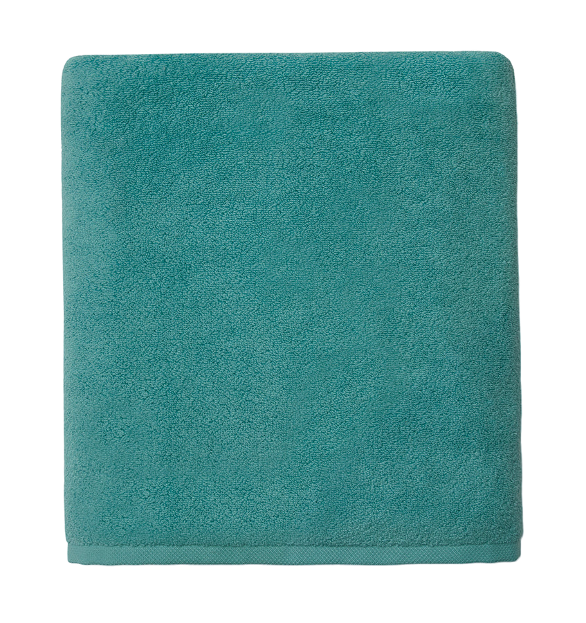 Sferra Cielo bath towel in teal, folded to display plush terry texture.