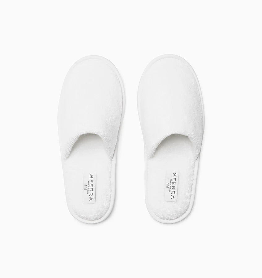 Pair of white slippers with 'Sferra' branding on a white background