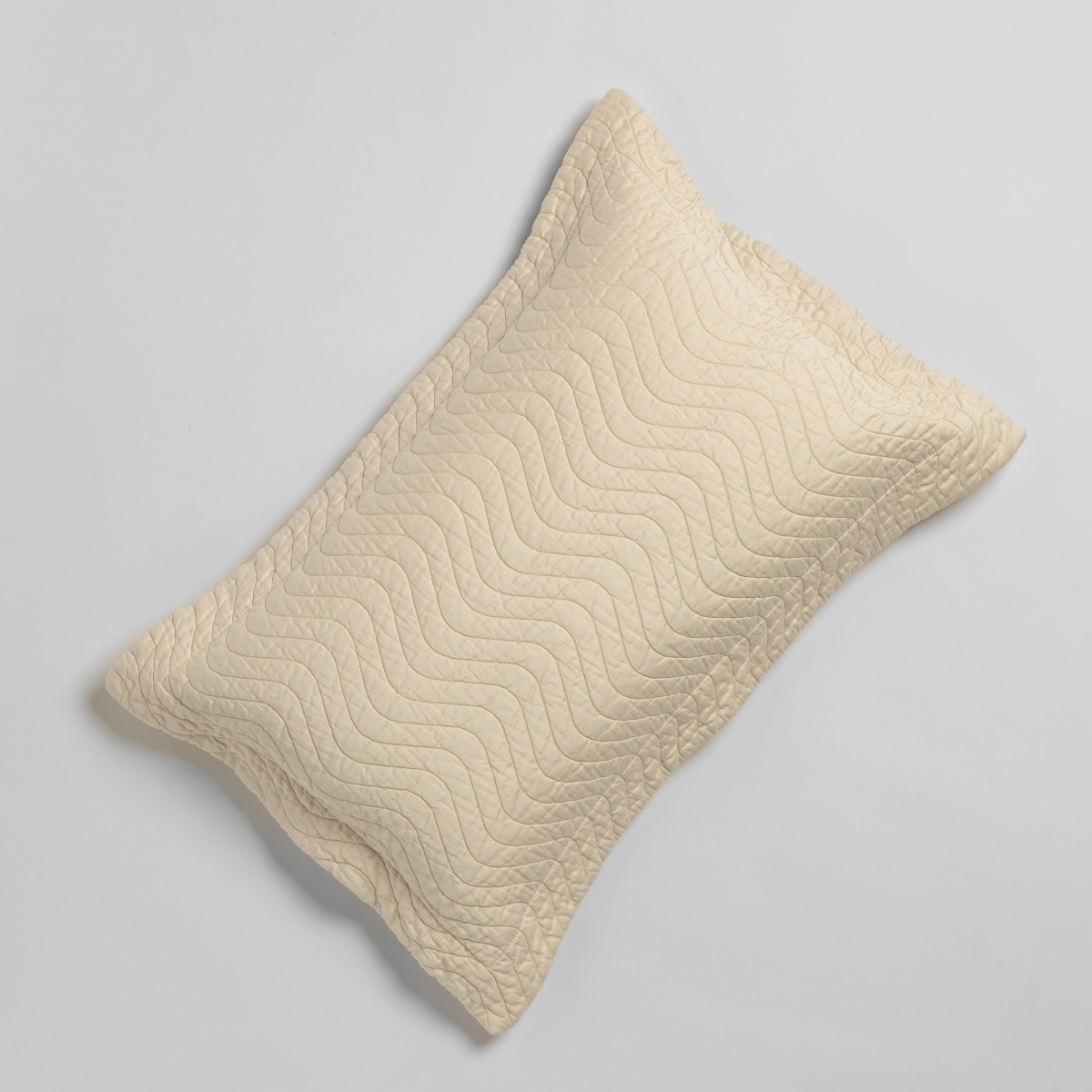 Bella Notte Cirillo throw pillow in Natural with quilted wave stitching pattern.