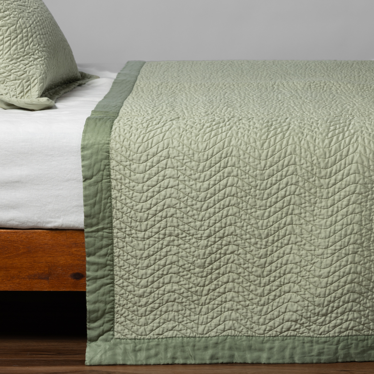 Cirillo coverlet corner detail showing Desert Sage quilted texture and darker border trim.