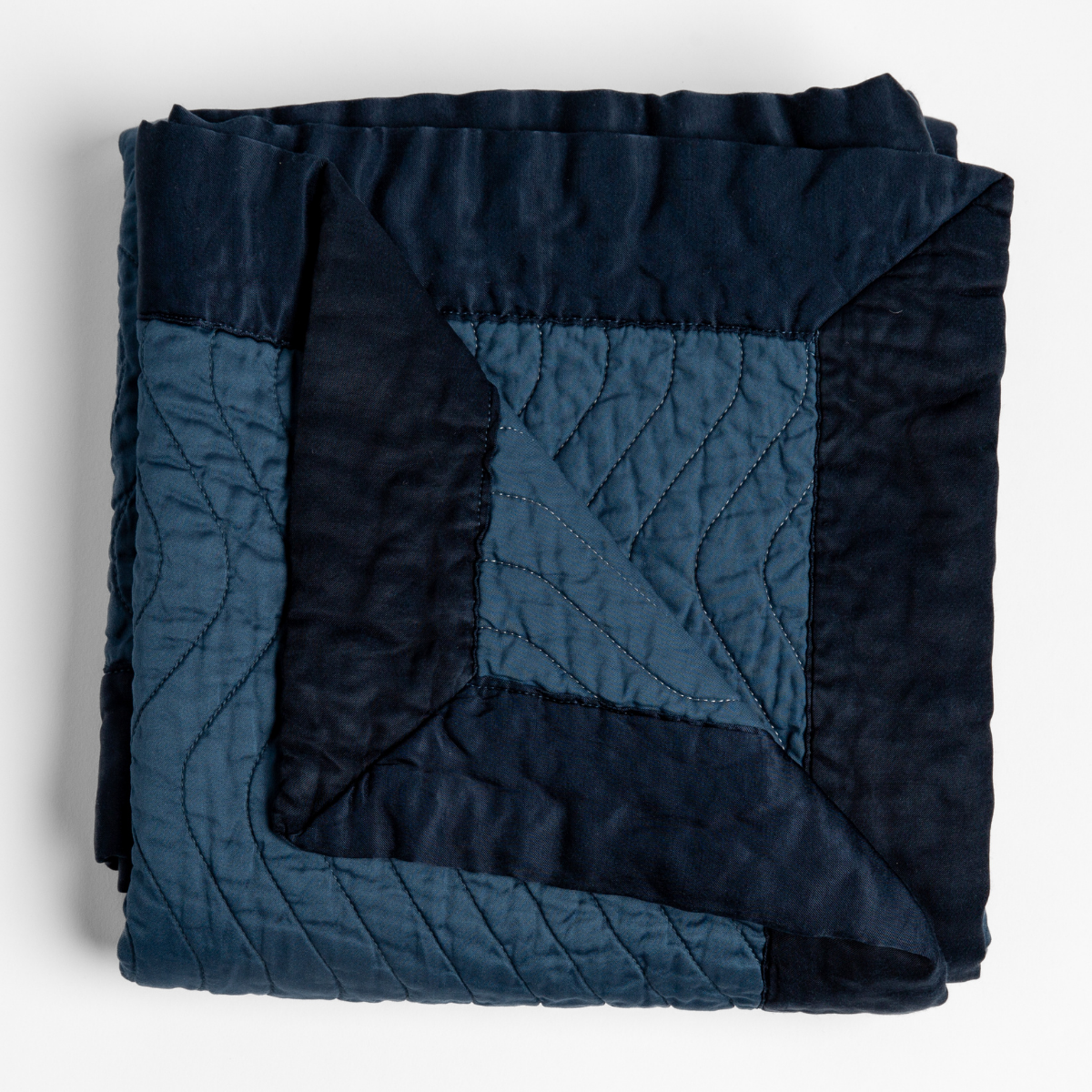 Bella Notte Cirillo blanket in Midnight, folded to show quilted panel border detail.