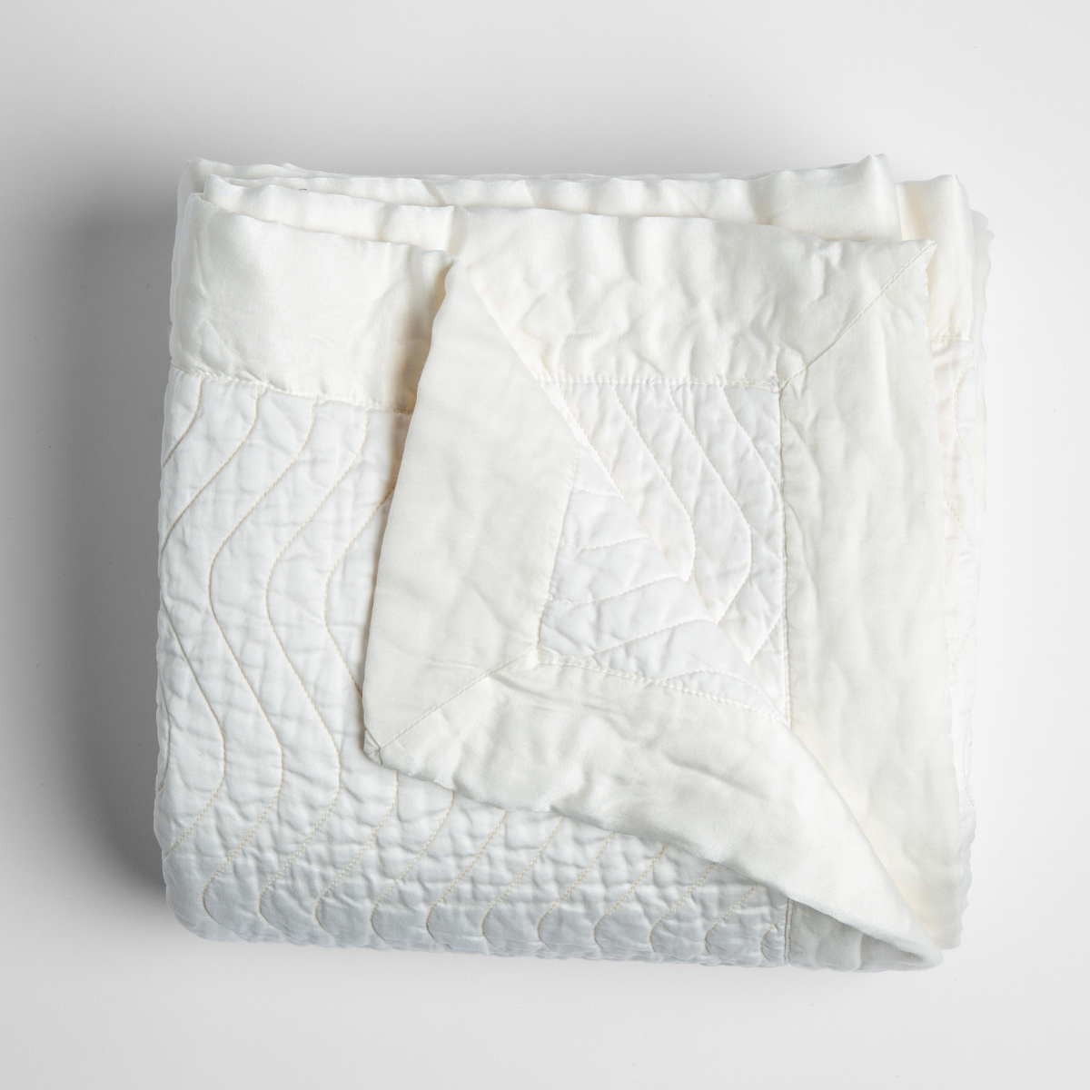 Bella Notte Cirillo blanket in White, folded to show quilted texture and reverse side.