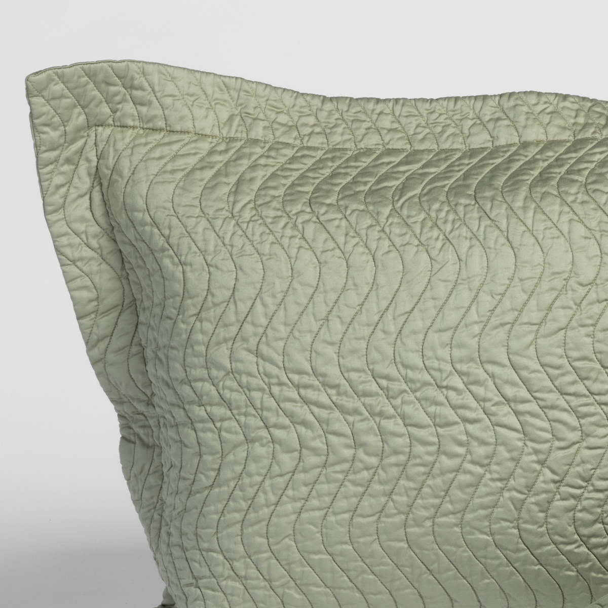 Close-up of Desert Sage quilted sham corner showing wave-pattern stitching detail.