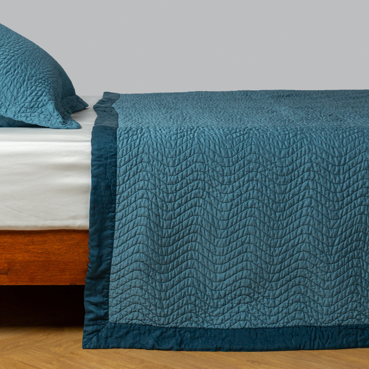 Bella Notte Cirillo coverlet in Cenote, showing wave-quilted texture and flange border detail.