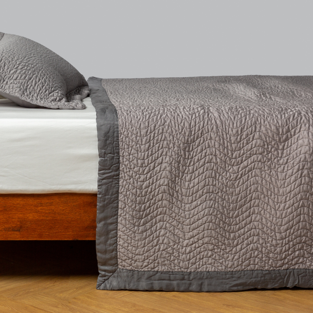 Bella Notte Cirillo coverlet in Fog, showing quilted wave texture and contrast border detail.