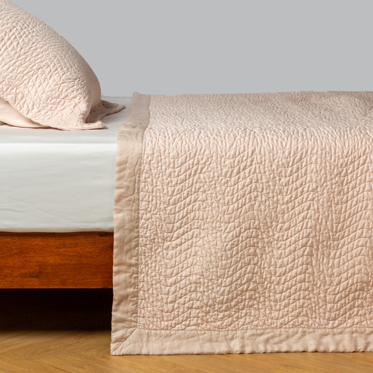 Bella Notte Cirillo coverlet in Pearl draped over bed foot, showing quilted texture detail.