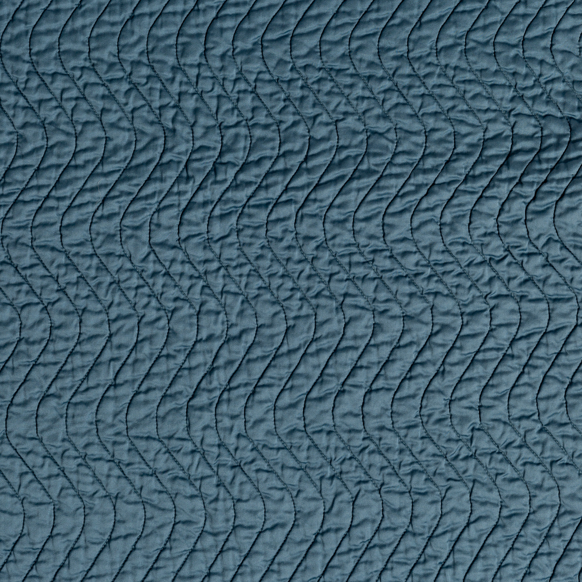 Close-up of Cenote Cirillo throw pillow's wave-quilted texture in teal velvet fabric.