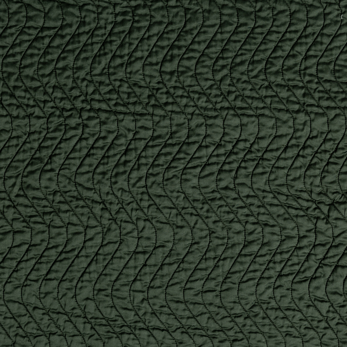 Close-up of Juniper Cirillo coverlet showing wave-stitch quilting texture on lustrous fabric.