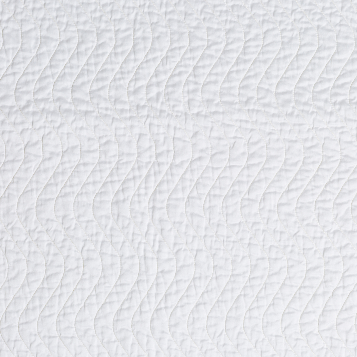 Close-up of Bella Notte Cirillo coverlet in White showing quilted wave texture detail.