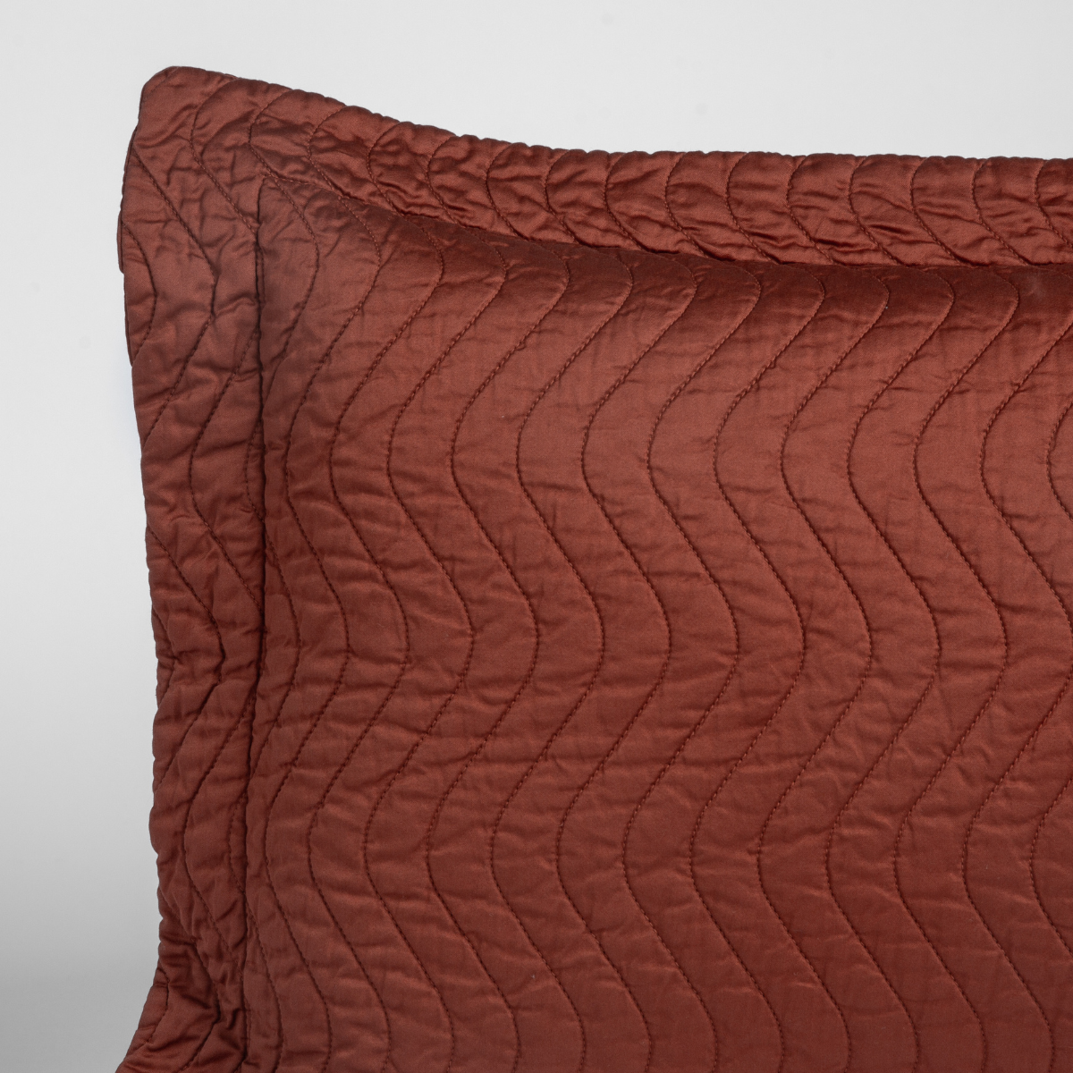 Close-up of Bella Notte Cirillo pillow corner showing wave quilting in Autumn.