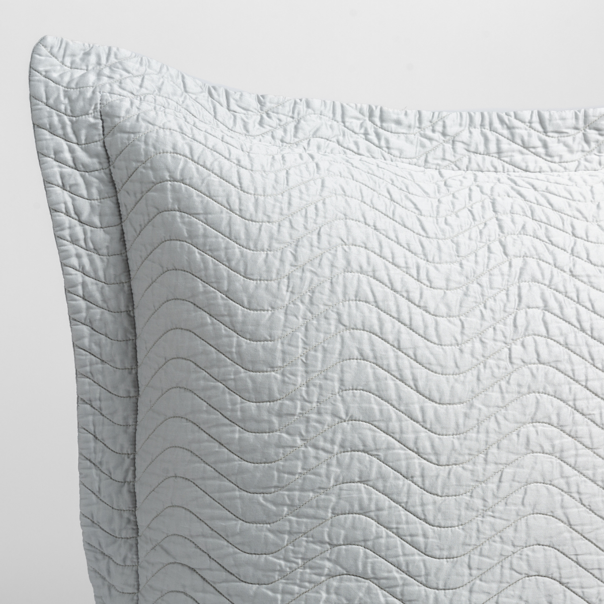Close-up of Bella Notte Cirillo sham corner in Cloud, showing wave-stitch quilting detail.