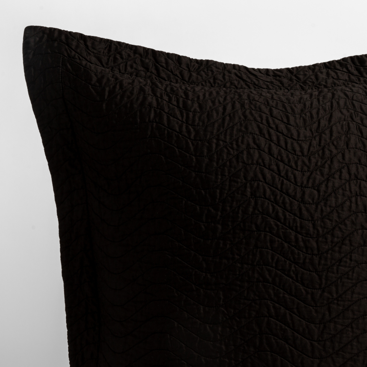 Close-up of Corvino Cirillo sham corner showing quilted texture and flange edge detail.