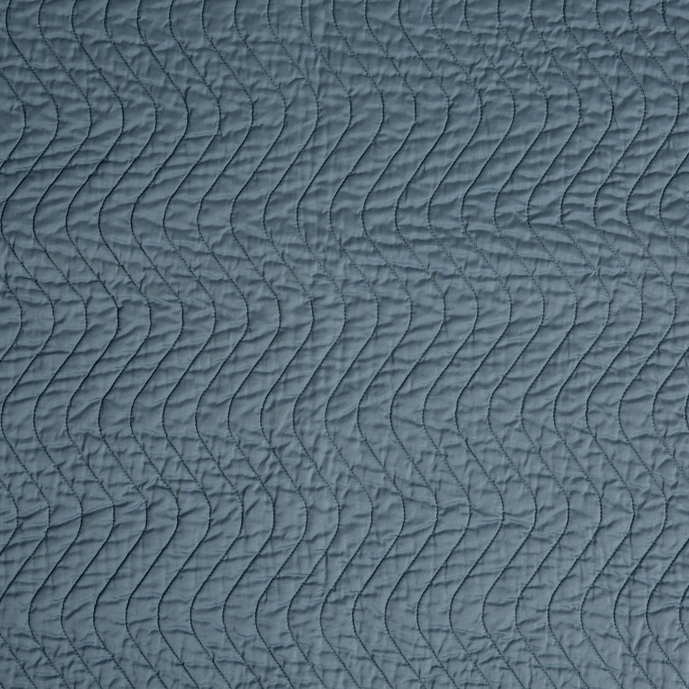Close-up of Tahoe Blue quilted Bella Notte Cirillo blanket with wave stitching detail.