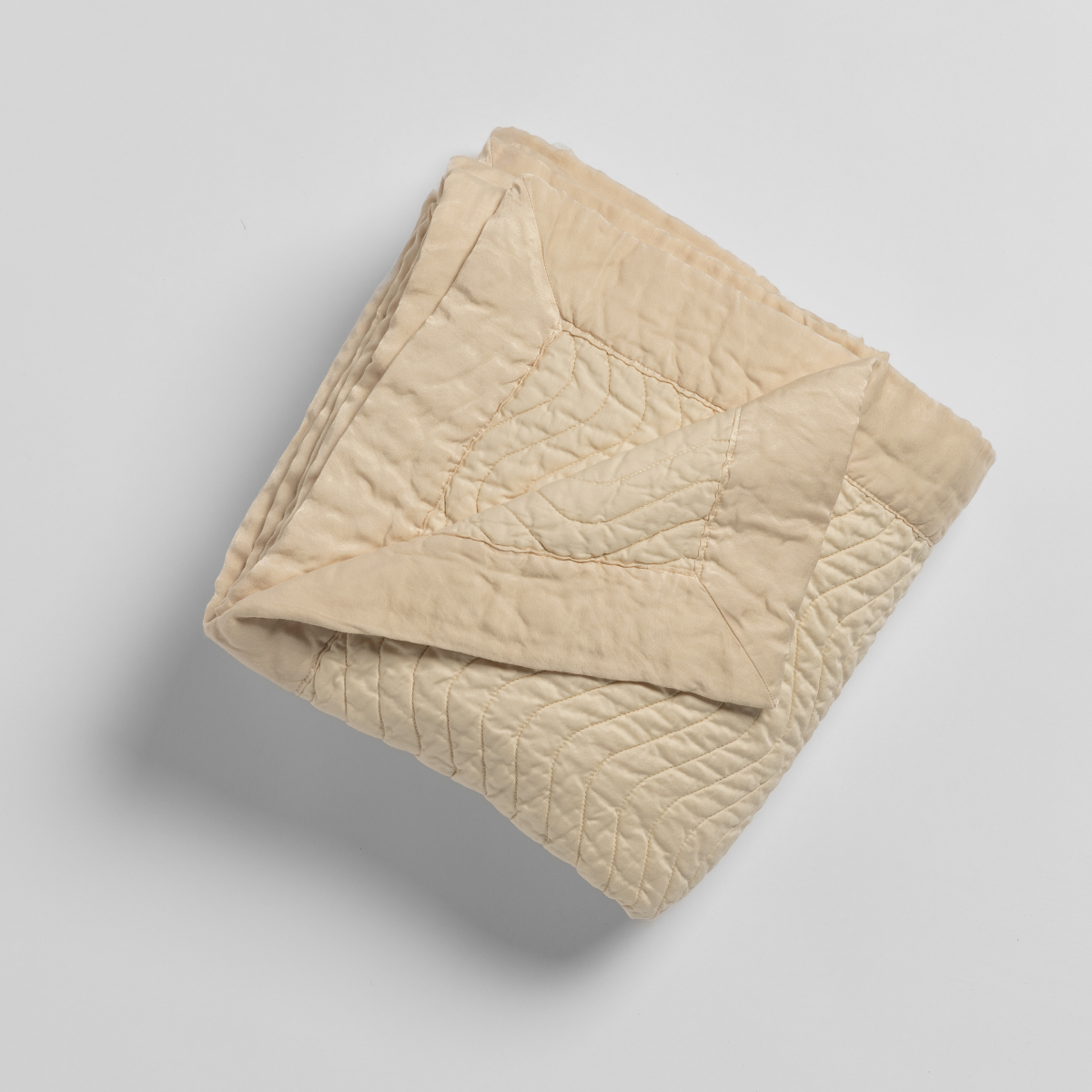 Bella Notte Cirillo blanket in Natural, folded to show quilted leaf pattern detail.