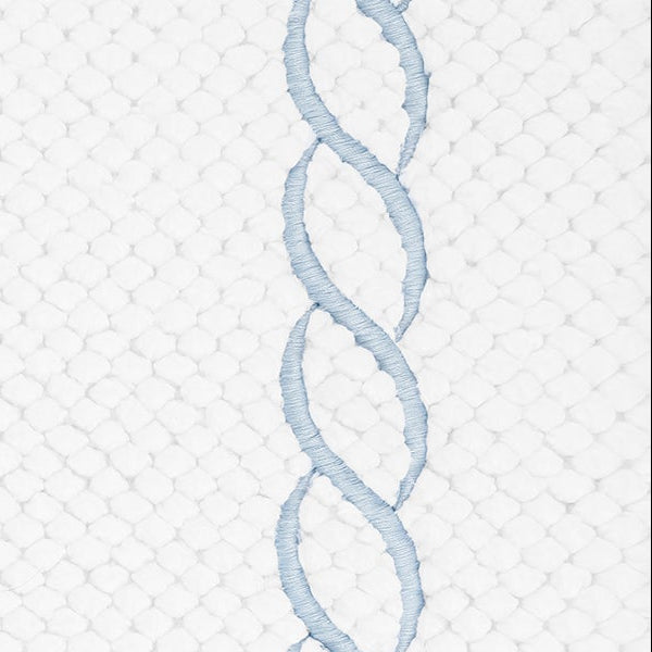 Close-up of powder blue chain embroidery on white honeycomb-weave cotton.