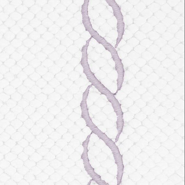 Close-up of lavender chain embroidery border on white textured cotton tub mat.