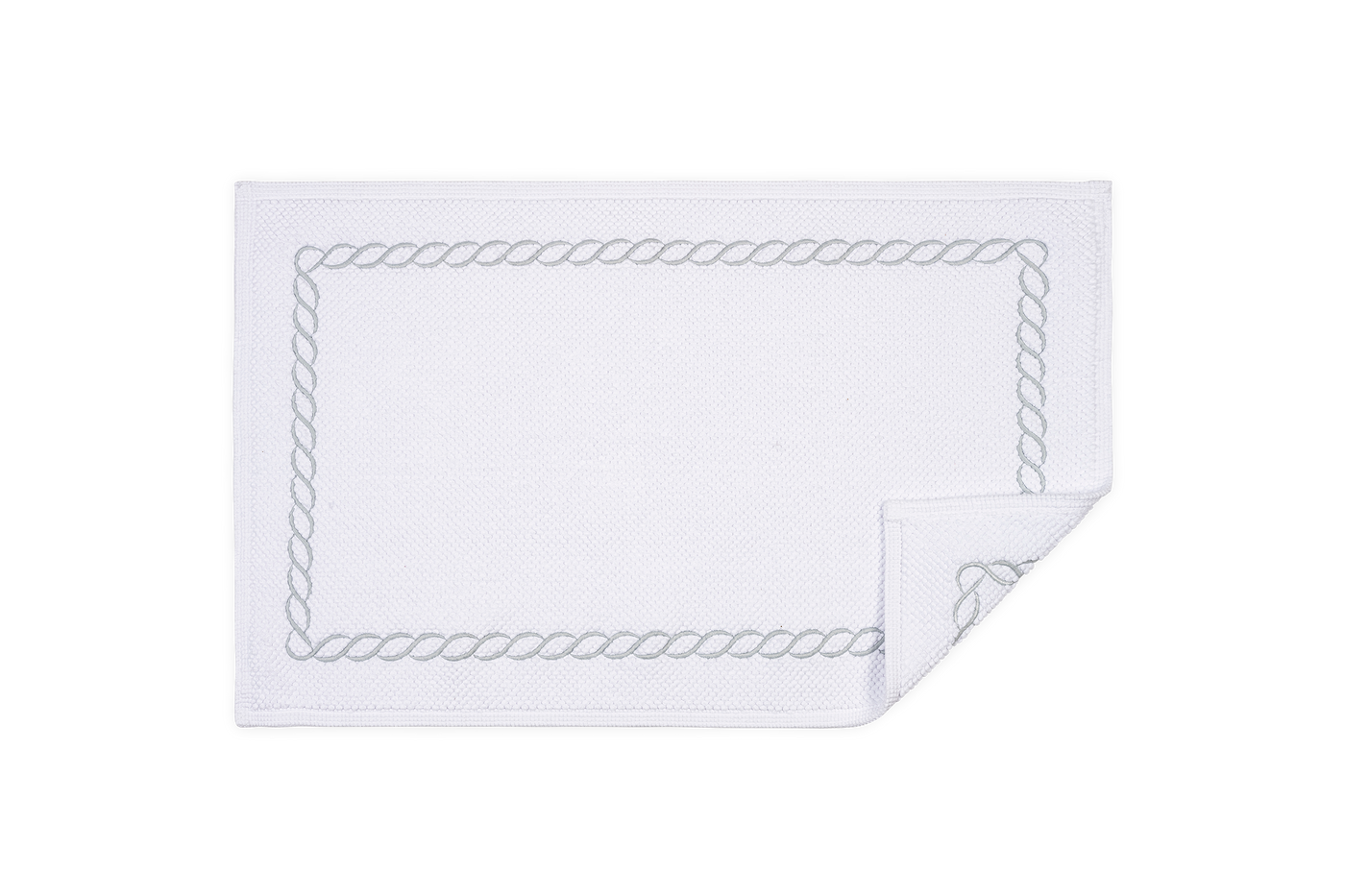 Corner detail of Matouk Classic Chain tub mat showing silver rope embroidery border on white.