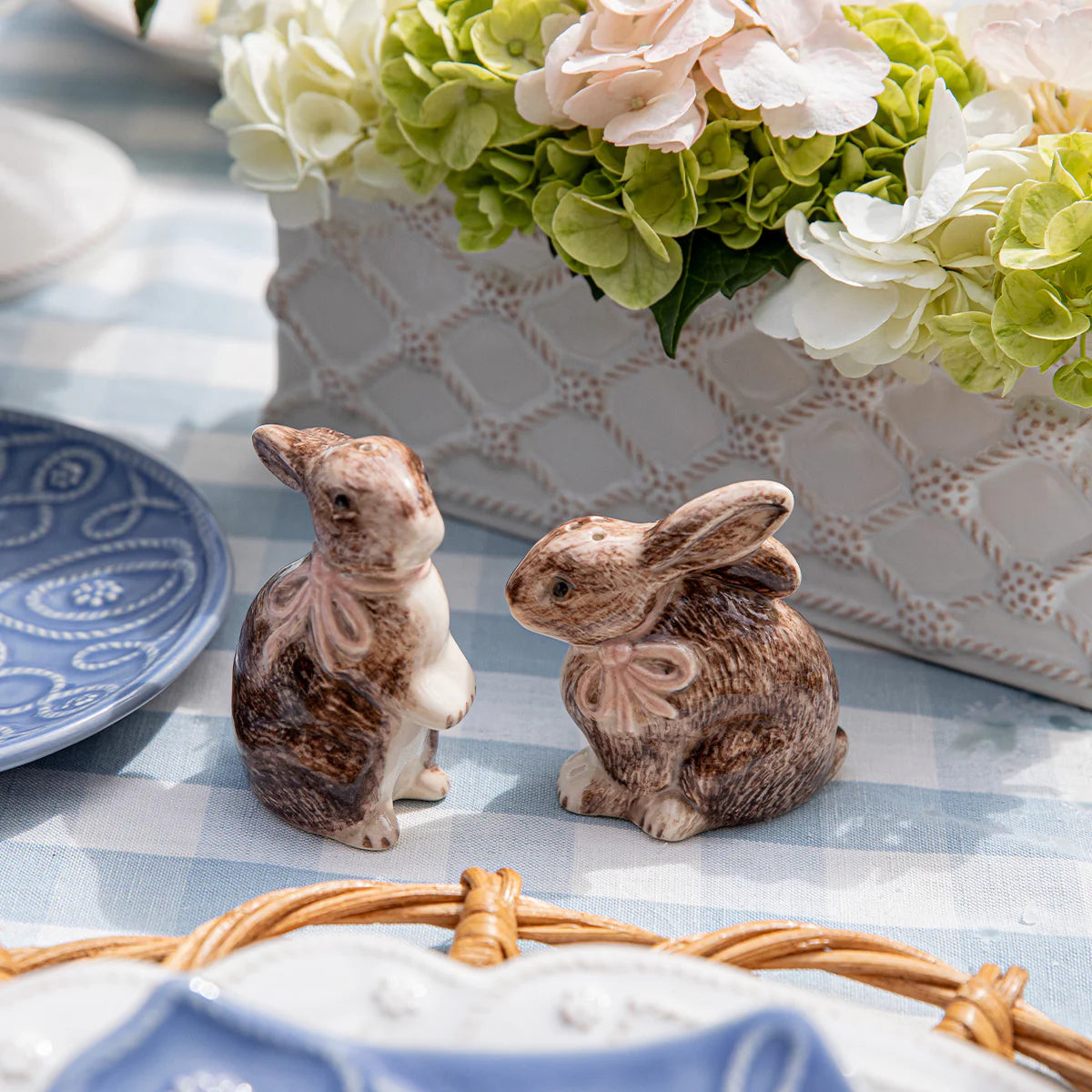 Brown ceramic bunny shakers with bow detail, styled on a blue gingham tablecloth.