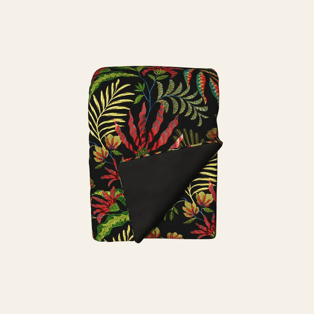 Ann Gish Cloud Forest throw, black ground with vivid tropical botanical print, corner folded back.