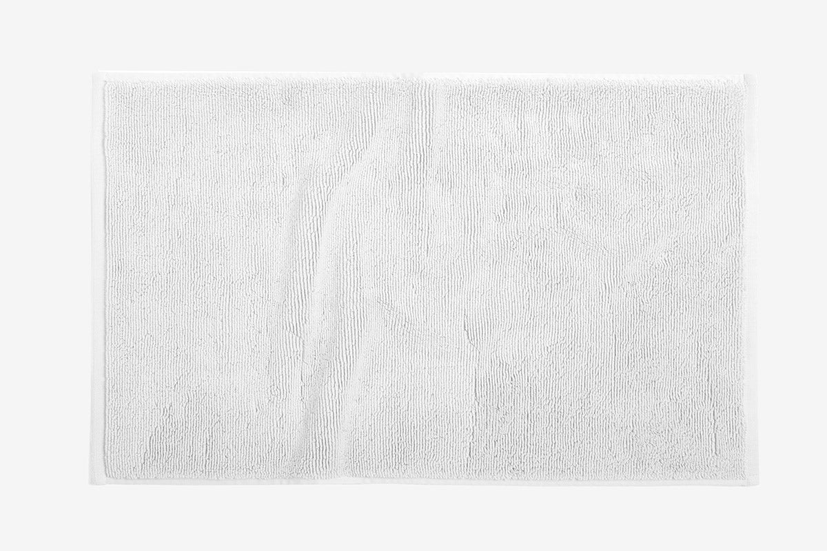 Coyuchi Cloud Loom bath rug in white, plush terry texture with subtle border detail.