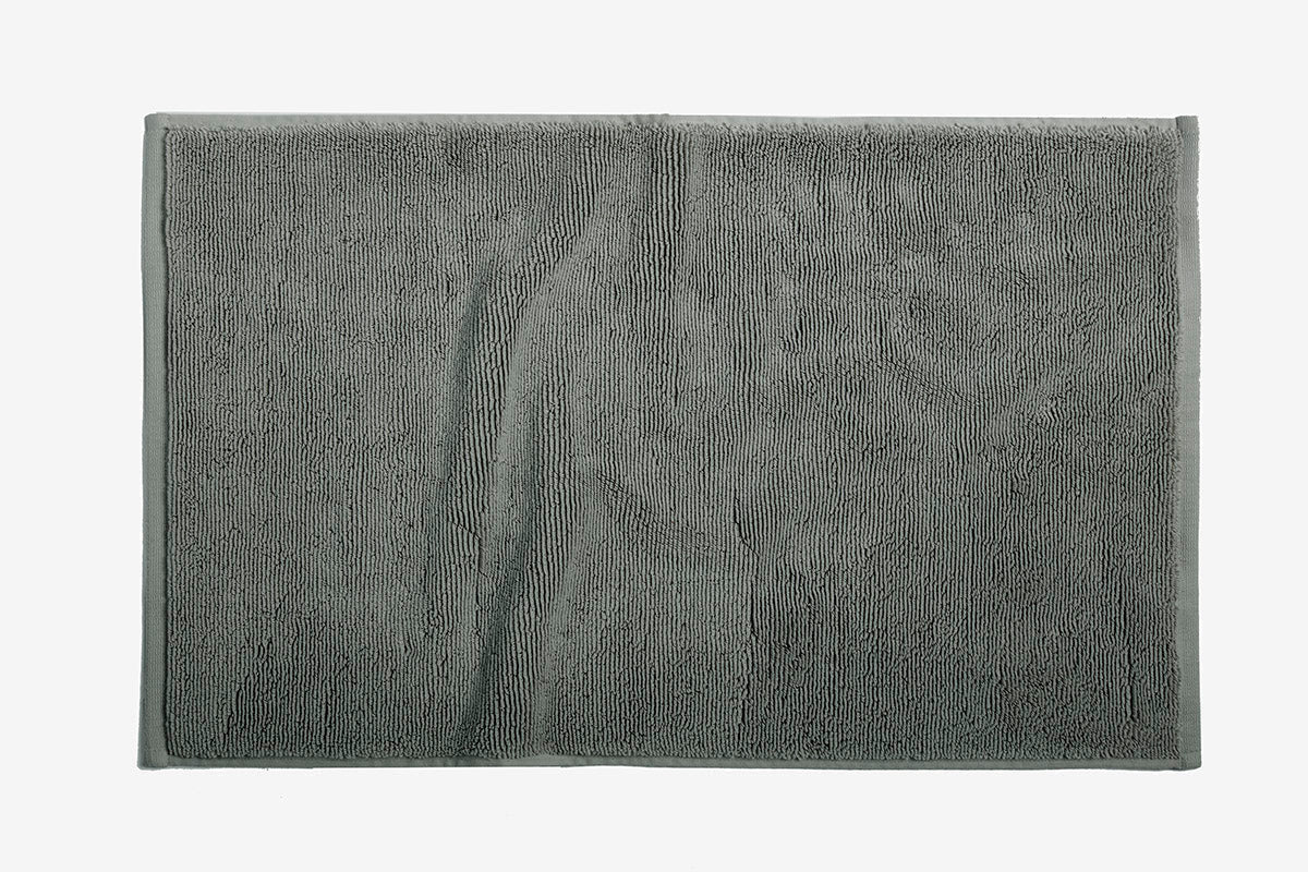 Close-up of Coyuchi Cloud Loom bath mat in slate grey, showing plush terry texture.
