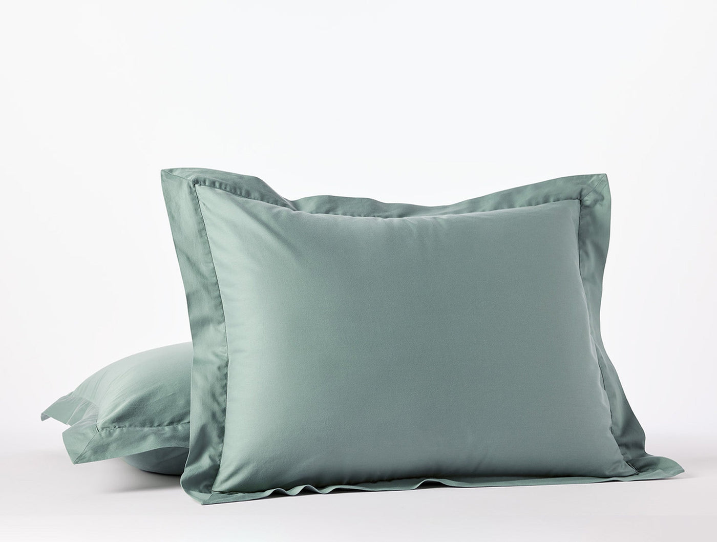 Two Coyuchi Cloud Soft Sateen pillow shams stacked in sage green with a classic flange border.