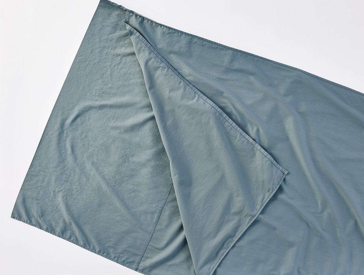 Coyuchi Cloud Soft Sateen Travel Sack in slate blue, folded flat showing interior lining.