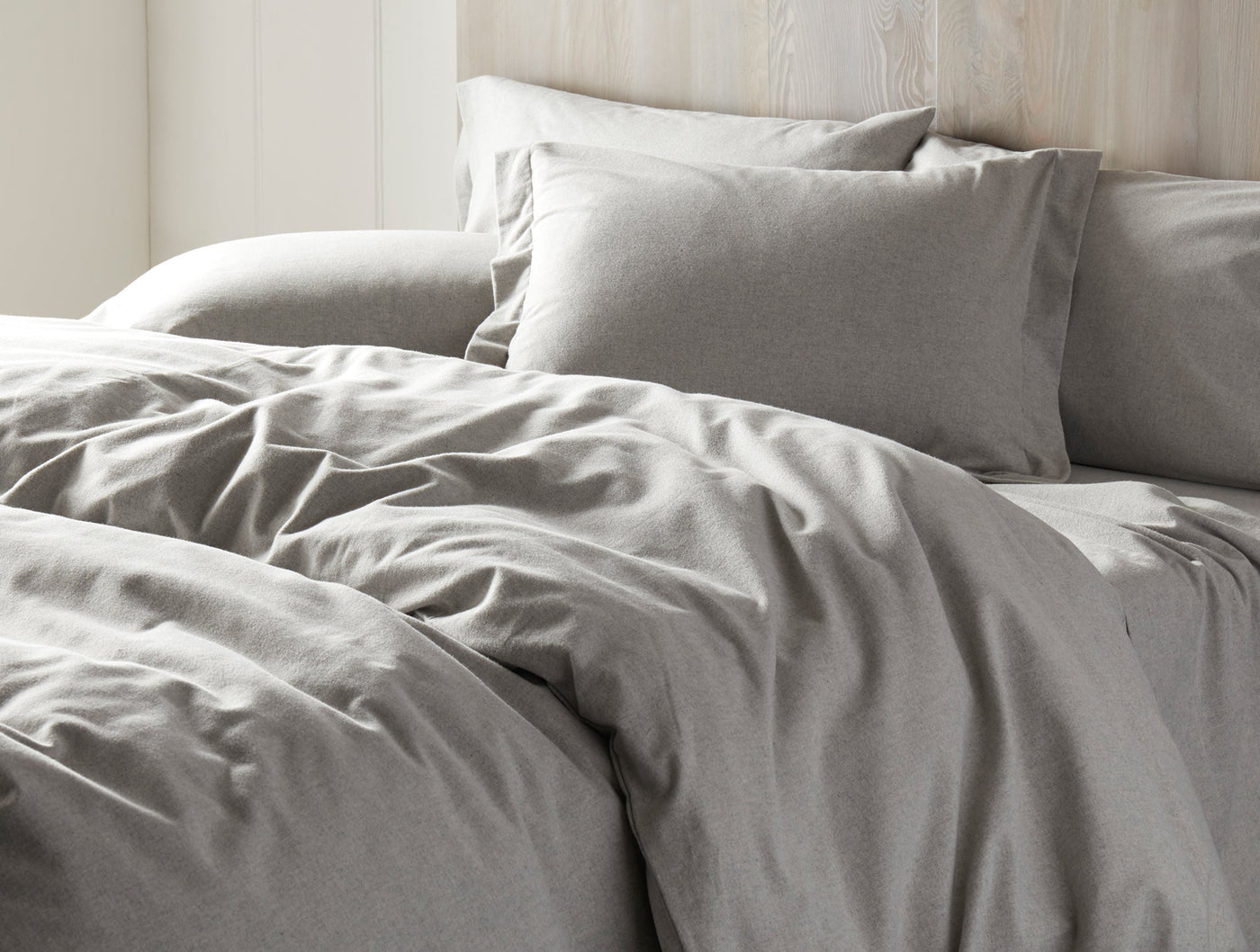 Close-up of heathered gray flannel bedding with softly rumpled duvet and matching pillows.