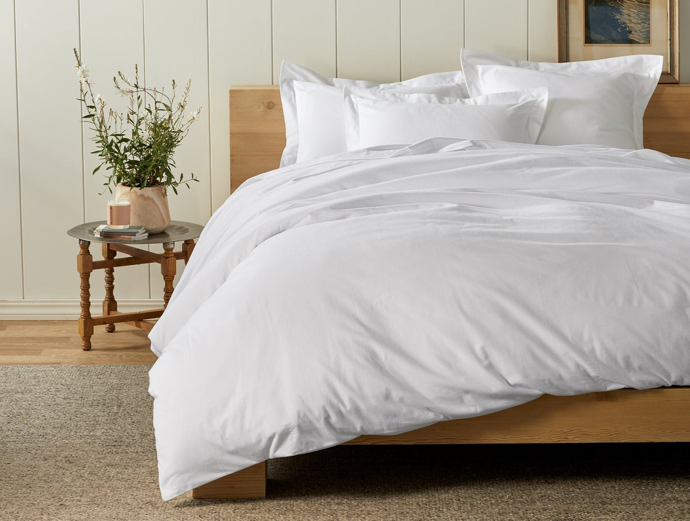 Coyuchi Cloud Brushed Flannel sheet set in white, styled on a natural wood bed.